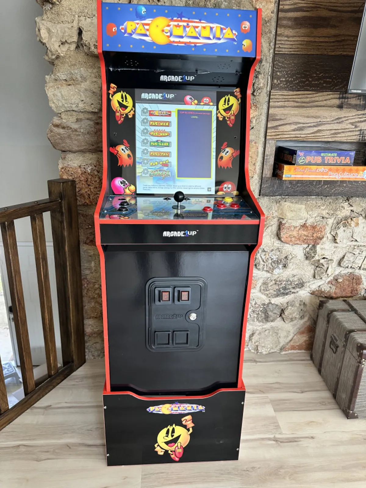 This image features a classic Pac-Man arcade machine set against a backdrop of wooden and stone wall textures. The setting is lively and nostalgic, evoking the fun of arcade gaming in a cozy environment.